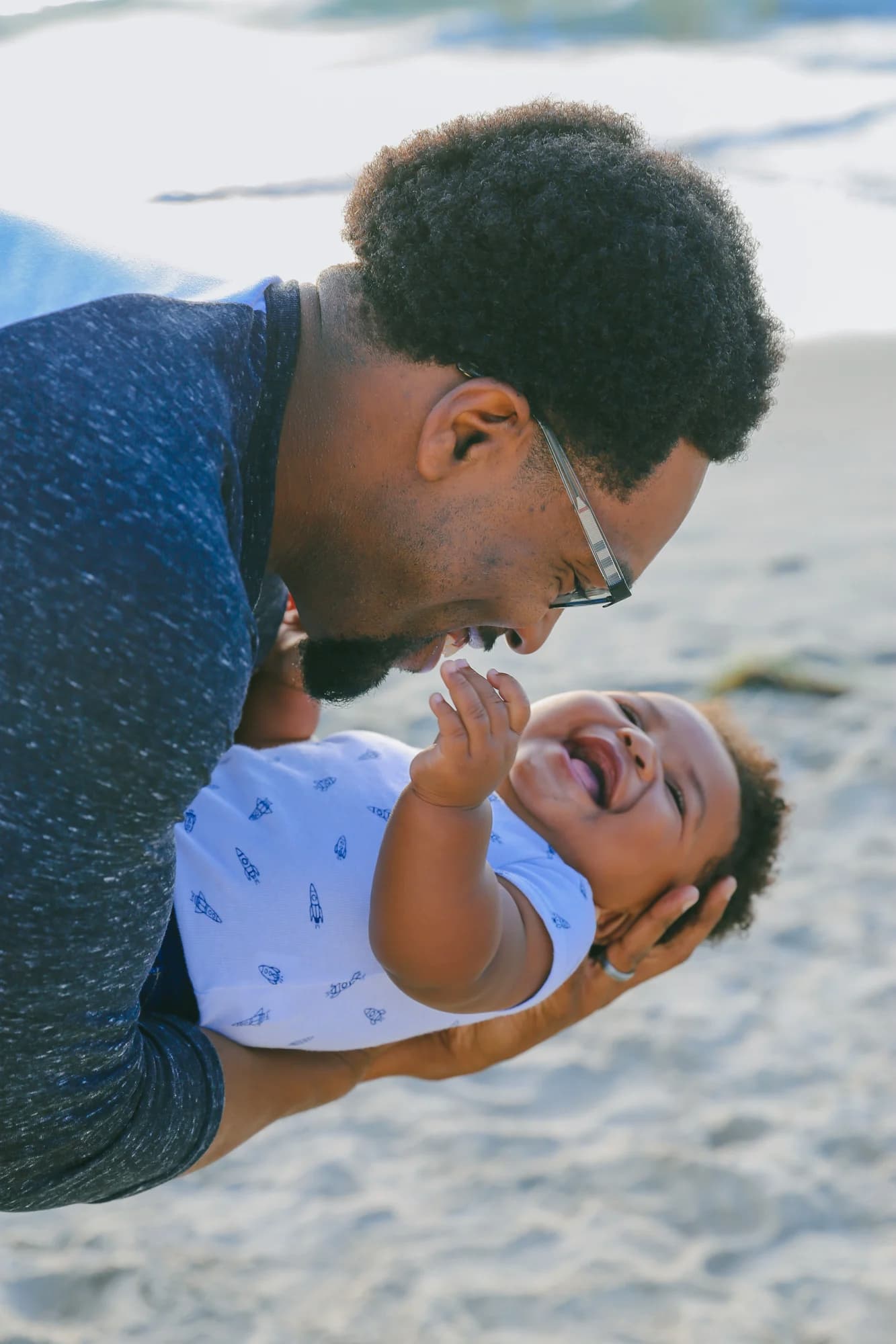 Happy Afro-American father cradles IVF baby, both smiling radiantly, celebrating their special bond and successful journey.