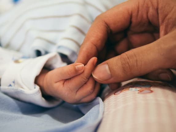 Baby hand held by an adult hand