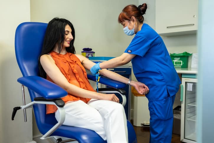 Fertility nurse taking blood from a female patient