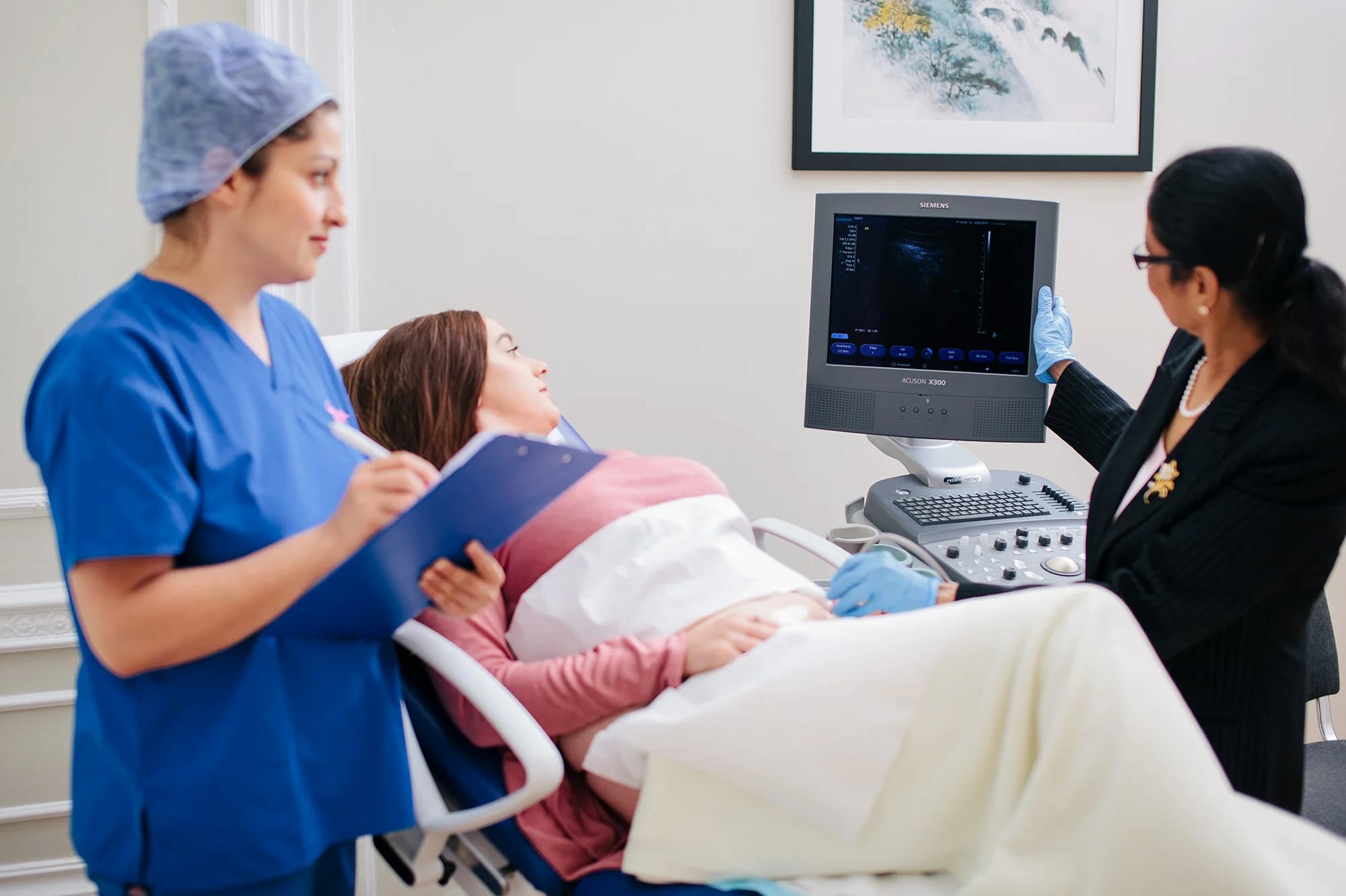 Dr Venkat and a nurse, showing a patient a scan.