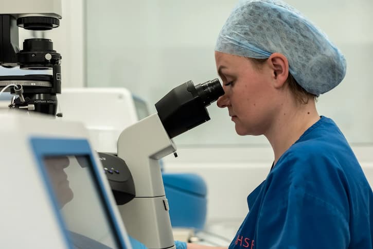 Embryologist looking through microscope