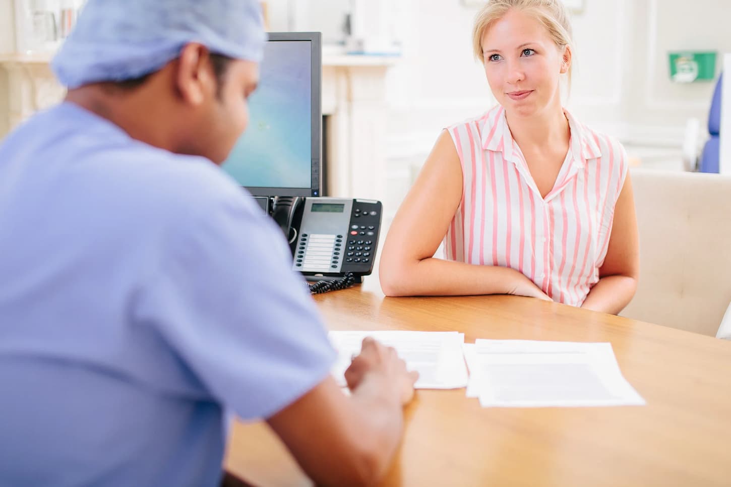 Male IVF doctor having a conversation with a female patient