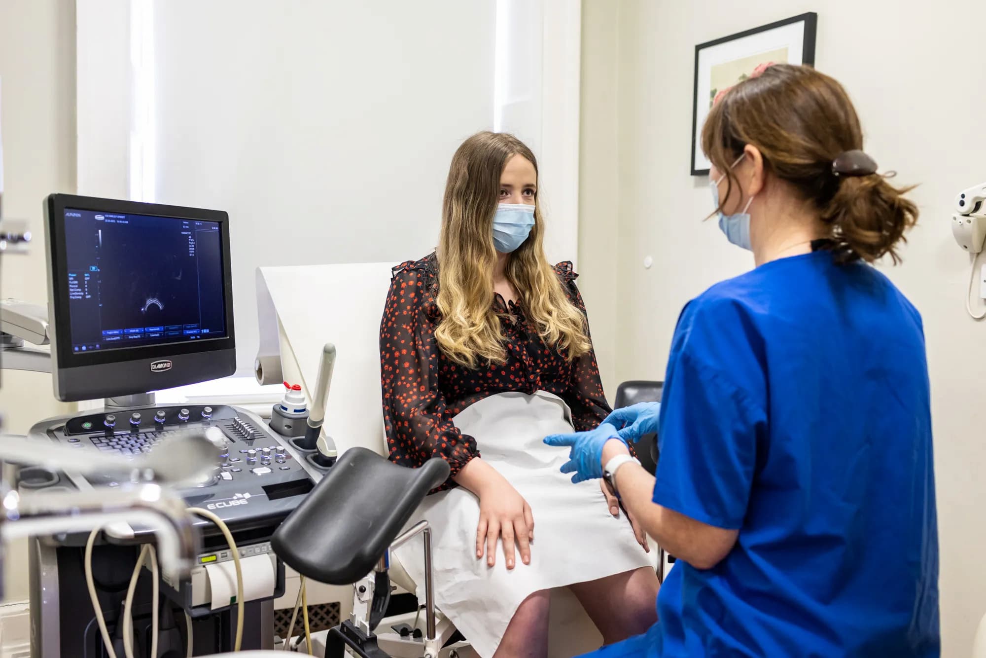 Patient and fertility doctor facing each other in a scan room