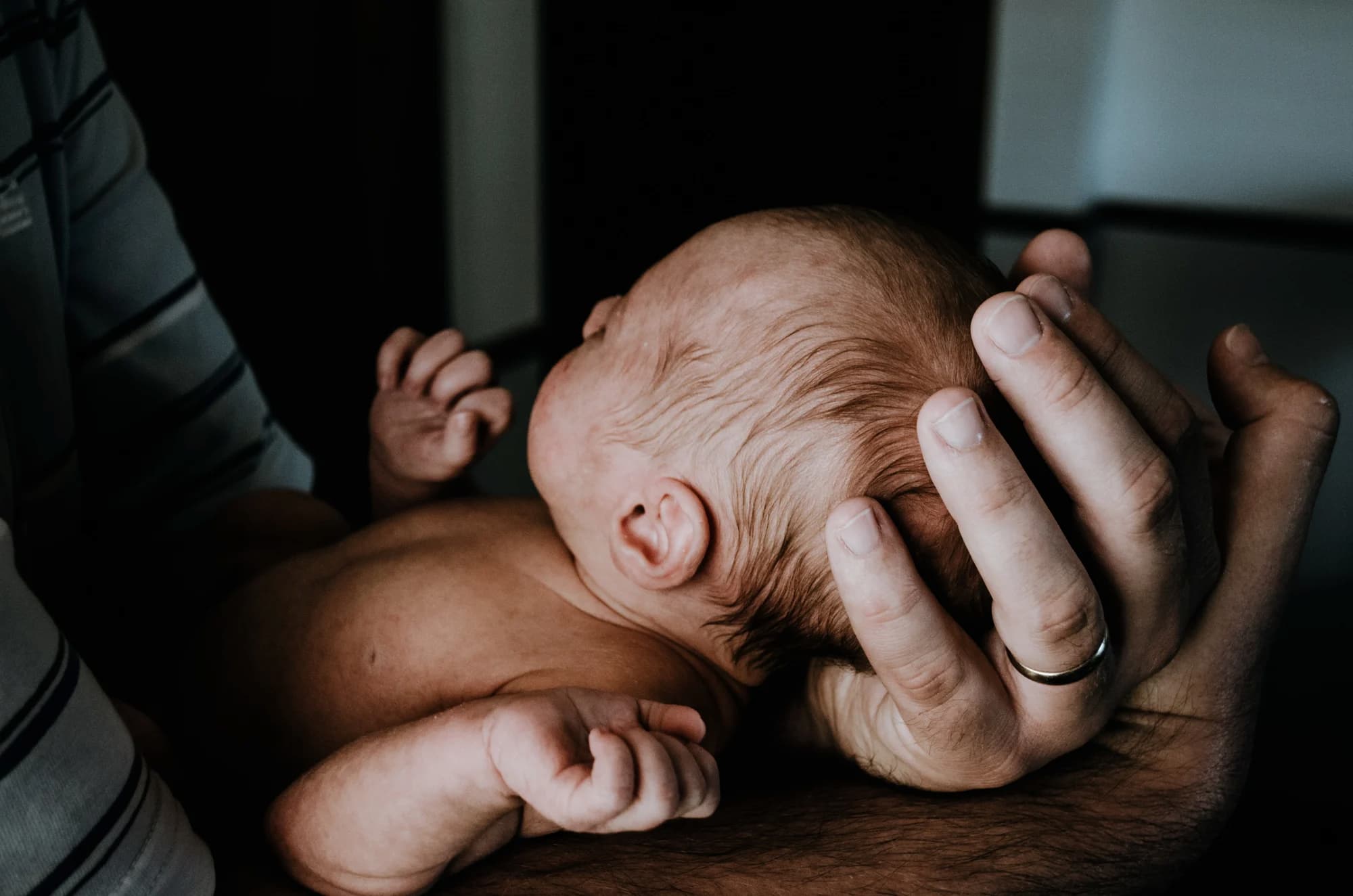 Baby held in adult arms